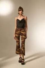 Pantalón de jean estampado camuflado en tonos marrones y beige, de corte flare, calce alto y ruedo deshilachado.