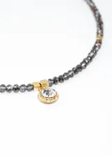 Gargantilla de mostacillas con punto luz, elaborada en acero quirúrgico hipoalergénico y strass, con cadena de extensión.