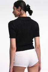 Top tejido de punto color lila con cuello polo y mangas cortas.