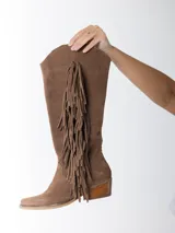 Botas texanas de caña alta color marrón, confeccionadas en gamuza con flecos laterales y taco de madera.