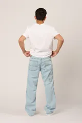 Pantalón de jean celeste de corte amplio, con bolsillos laterales y traseros.