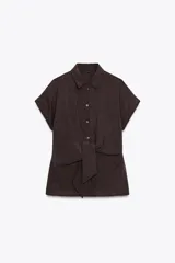 Camisa marrón con cuello solapa y mangas cortas. Cierre frontal con nudo y botones.