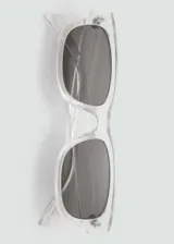 Lentes de sol rectangulares transparentes con lentes grises.