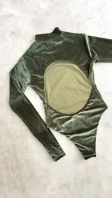 Body de terciopelo marrón con estampado de piel de serpiente, cuello alto, mangas largas con orificio para el pulgar y espalda descubierta.