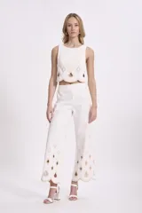 Conjunto de top crop y pantalón palazzo negros con bordados calados en forma de rombos con borde festoneado en color crudo.