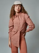 Camisa de manga larga color ladrillo con rayas blancas, confeccionada en lino. Tiene cuello clásico, cierre frontal con botones y bolsillo de parche en el pecho.