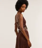 Vestido largo marrón de malla de poliéster con elastano, escote halter, espalda abierta, breteles finos y textura agujerada con forro.