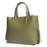 Cartera tipo tote grande color verde, confeccionada en cuero sintético. Tiene doble asa corta, correa larga regulable y desmontable, acceso superior abierto y herrajes plateados.