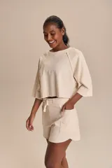 Short color crudo de algodón, de tiro alto y corte holgado, con cintura ajustable mediante cordón.