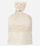Top sin mangas color crema con textura calada en patrón de ondas. Presenta un escote halter que se ata en la parte superior con un lazo ancho y un anillo metálico dorado como conector central.