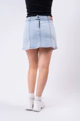 Minifalda de jean de tiro alto, color celeste claro lavado, con roturas sutiles y aberturas frontales en el ruedo.