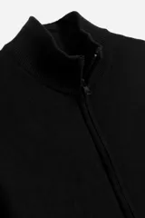 Campera negra de tejido de punto, con cuello alto, cierre frontal y mangas largas.