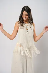 Blusa beige de lino bordado, sin mangas y con terminación en flecos.