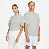 Camiseta gris de corte holgado con logotipo bordado de Nike en el pecho.