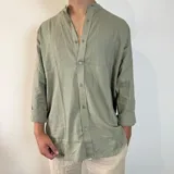 Camisa verde oliva de lino con cuello mao y mangas largas con puños abotonados. Corte oversize.