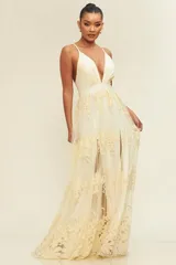 Vestido largo color crema con breteles finos, escote en V pronunciado y falda de tul con bordado floral.