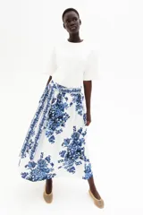 Pollera midi de corte holgado en popelina de algodón con estampado floral en tonos azules. Tiene tiro alto, tira ancha en un lateral y cierre oculto.