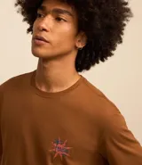 Remera marrón de algodón con estampa en la espalda que incluye una palmera, un sol y el texto "Waikiki Shore".