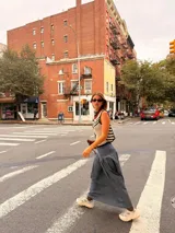 Falda larga de tela de jean con diseño de caderín y tablas.