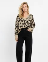 Buzo tejido de lana color beige con estampado animal print de leopardo en negro, escote en V y mangas largas. Marca Q2, talle Medium.