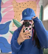 Gorro de gabardina azul con visera, con la letra K bordada en blanco en el frente.