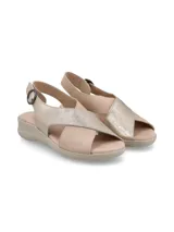 Sandalias color beige con tiras cruzadas en la capellada, una tira color dorado y otra color beige. Tiene una tira trasera con hebilla para ajustar al tobillo y suela baja.