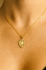 Collar dorado con dije ovalado de la Virgen María con borde de strass.