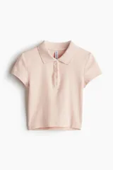 Remera polo color rosa claro, de punto acanalado, manga corta, cuello clásico y tapeta de botones.