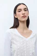 Remera verde petróleo con escote en V, mangas tres cuartos y diseño de broderie calado.