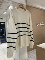 Sweater de tejido Bremer negro con rayas horizontales color tostado, de corte holgado y cuello redondo.