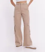 Pantalón cargo de sarga color beige, corte sastrero, con cintura alta, trabillas, cierre con botón y cremallera, y bolsillos laterales tipo cargo.
