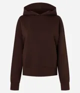 Buzo femenino color blanco crema, confeccionado en algodón y poliéster, con capucha estructurada, bolsillo canguro delantero y puños acanalados.