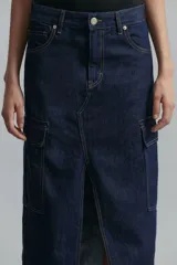 Falda midi de denim azul oscuro, con tiro medio, calce regular, abertura frontal y bolsillos laterales tipo cargo.