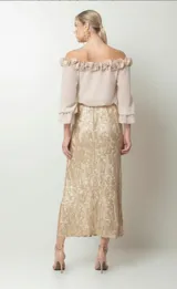 Falda midi dorada con estampado floral y cintura elastizada.