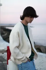 Cardigan de punto color crema con botones. Corte clásico y amplio.