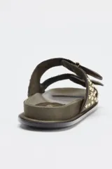 Sandalias planas color verde militar con doble tira con hebillas y tachas metálicas.