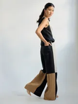 Pantalón ancho de corte recto con fit holgado, de lino color beige con bloques de color negro y marrón.