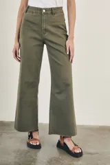 Pantalón wide leg color beige, de tiro alto, ligeramente ajustado en cintura y con ruedo desflecado.