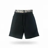 Bermuda negra de corte holgado con cintura doble. La cintura interior es elástica y presenta un estampado de camuflaje tipo bosque (Realtree). Posee cordón de ajuste frontal.