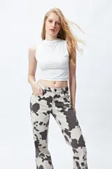 Pantalón de denim con estampado de vaca, tiro medio, corte recto y cinco bolsillos.