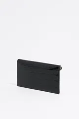 Monedero negro de Bimba y Lola con textura brillante tipo piel de cocodrilo y estructura blanda. Tiene logo metálico dorado, cierre con botón de presión e interior con logo grabado.