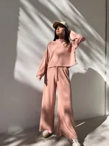 Conjunto deportivo color rosa compuesto por un buzo de cuello alto y mangas largas, y un pantalón palazzo con cintura elastizada y cordón ajustable.