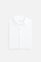 Camisa blanca de algodón, corte regular, con cuello italiano abierto, manga larga con puños abotonados y cierre frontal con botones.