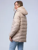 Campera acolchada tipo puffer de color beige, con costuras horizontales y capucha integrada con cordones ajustables negros. Presenta cierre frontal negro y bolsillos laterales.