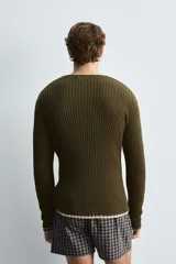 Cárdigan de hombre color verde oliva, tejido de punto canalé en hilatura de algodón, de corte regular fit, con cuello redondo, manga larga y cierre frontal con botones.