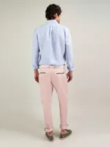 Camisa celeste a rayas verticales de lino, corte regular fit, cuello italiano, cierre con botones, manga larga terminada en puño simple y logo bordado en el pecho.