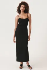 Vestido midi negro de breteles finos, escote recto y falda ajustada con abertura lateral.