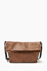 Bolso bandolera color tostado con correa negra y solapa con cierre magnético.