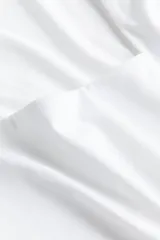Top blanco de punto elástico, corte entallado, con escote cuadrado y mangas cortas.