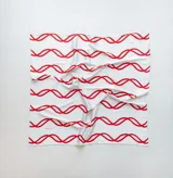 Pañuelo de seda con estampado que evoca ondas del mar, en tonos blanco y marrón.